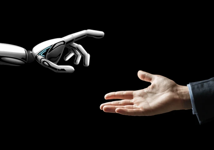 A robot hand and a human hand coming together.