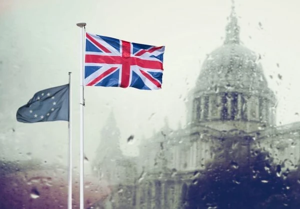 EU and Union Jack flags flying in front of St Paul's Cathedral in the rain