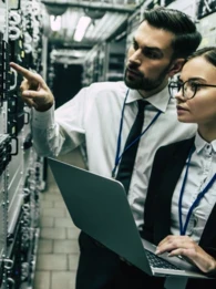 Two businesspeople standing in a server room.