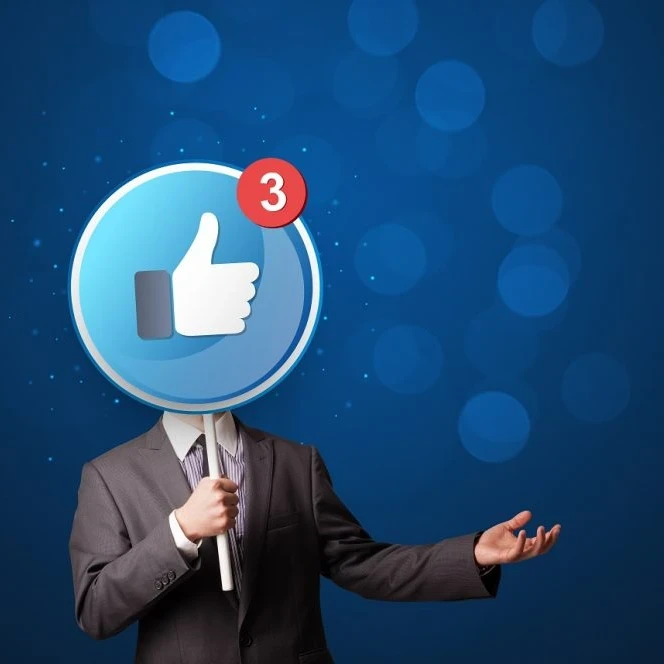 Image showing a man dressed in a suit holding up a large lollipop sign with a thumbs up emoji and sign for 3 unread notifications in Facebook branding